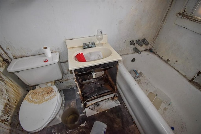 bathroom with a washtub, vanity, and toilet