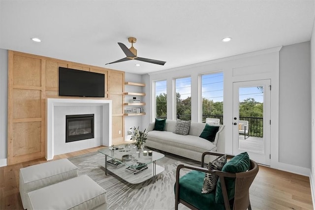 living room with ceiling fan, light hardwood / wood-style floors, and crown molding