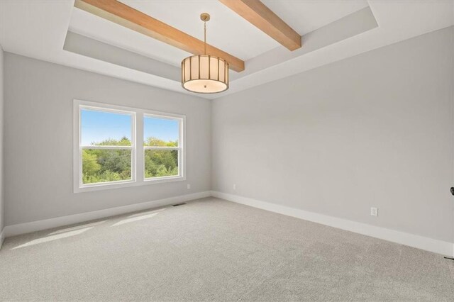 spare room with beamed ceiling and carpet flooring