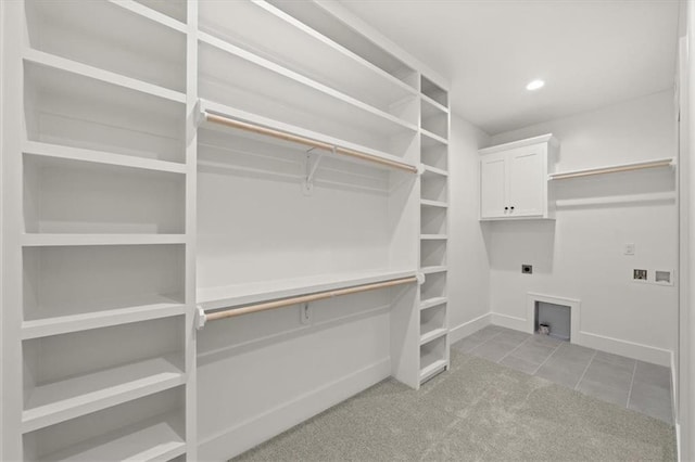 spacious closet featuring light colored carpet