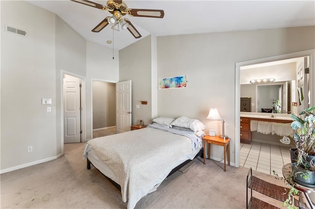 carpeted bedroom with ceiling fan, high vaulted ceiling, and ensuite bath