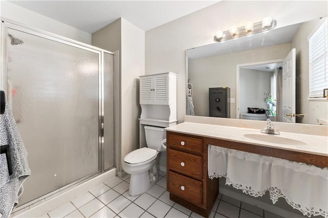 bathroom featuring tile patterned floors, vanity, toilet, and a shower with door