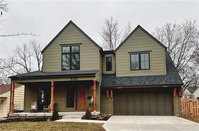 view of front of home featuring a garage, covered porch, and a front lawn