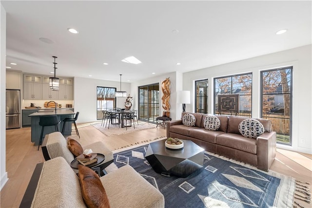 living room with sink and light hardwood / wood-style flooring