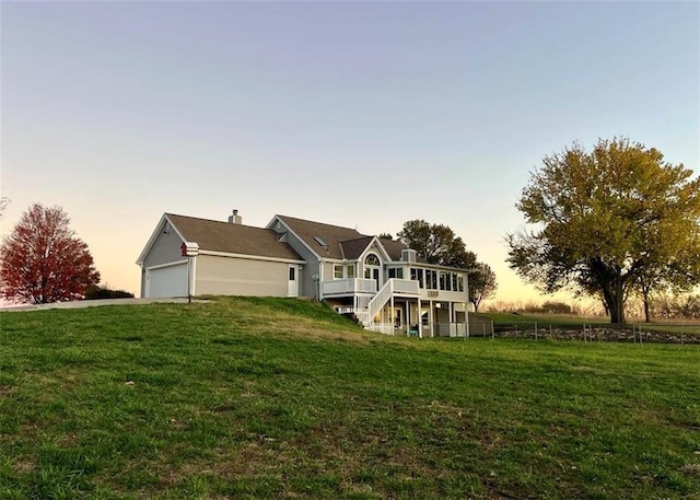 exterior space with a garage, a wooden deck, and a lawn