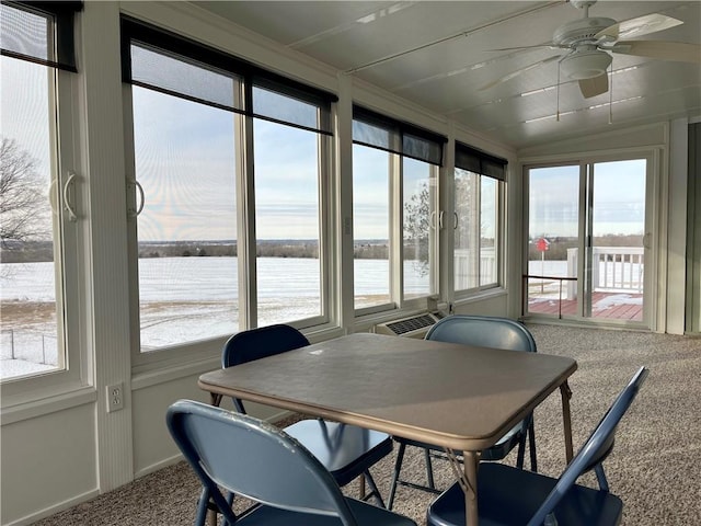 sunroom / solarium with ceiling fan and a water view