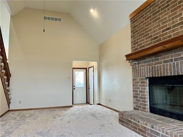 unfurnished living room with a brick fireplace, carpet, and high vaulted ceiling