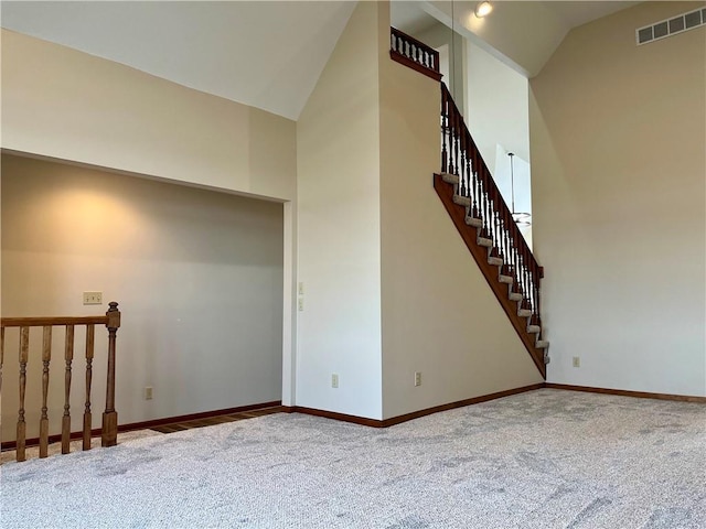 stairs with carpet and high vaulted ceiling