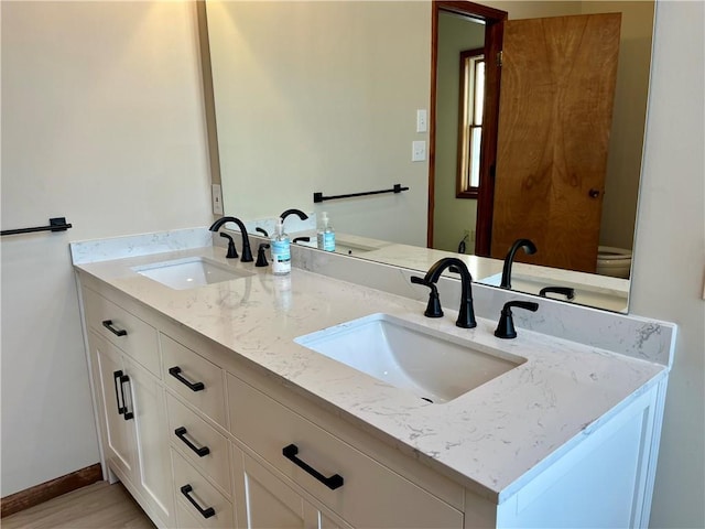 bathroom featuring hardwood / wood-style flooring, vanity, and toilet