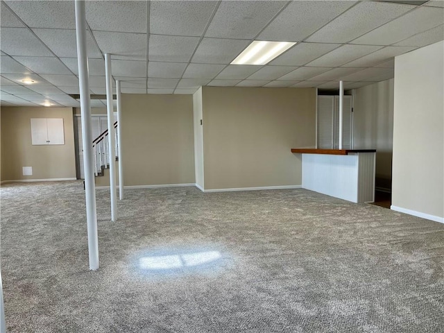 basement featuring carpet flooring and a drop ceiling