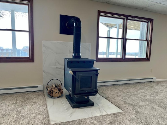 interior details featuring a baseboard radiator, carpet, and a wood stove