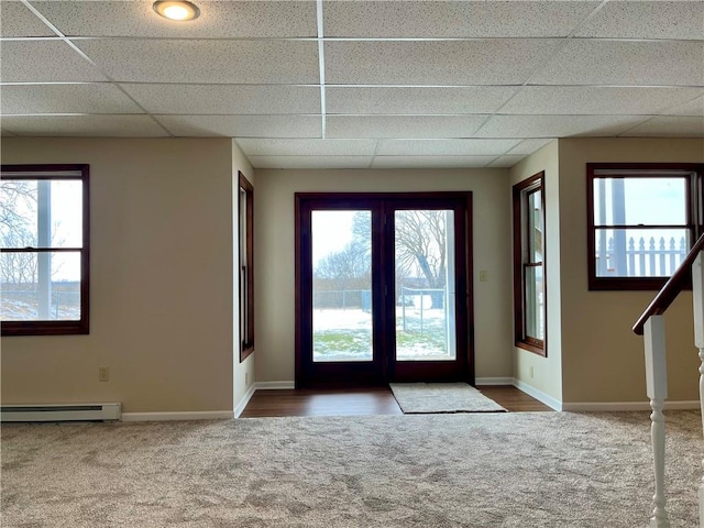 doorway featuring carpet, a baseboard heating unit, and a drop ceiling