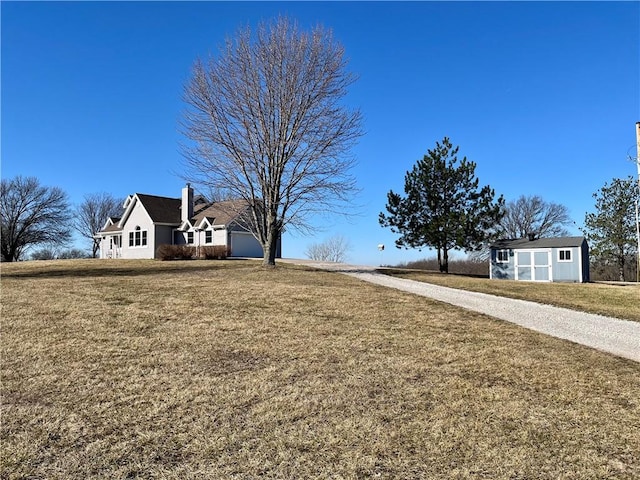 view of yard with a garage and driveway