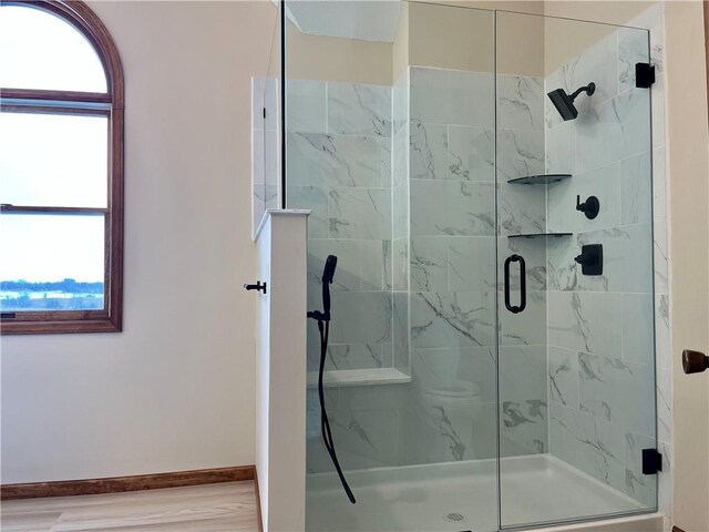 full bathroom with baseboards, wood finished floors, and a shower stall