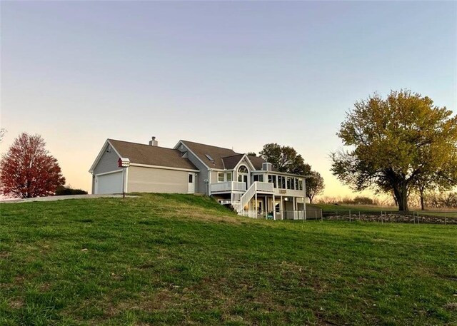 back of house at dusk with a lawn