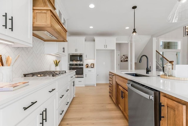 kitchen with white cabinets, custom range hood, stainless steel appliances, and tasteful backsplash