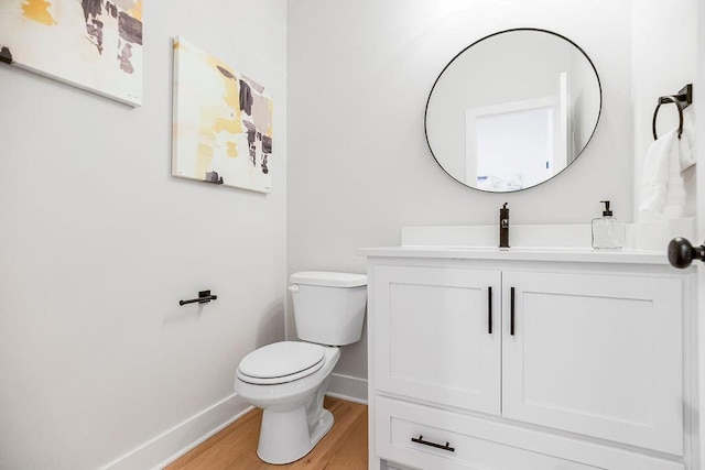 bathroom with hardwood / wood-style floors, vanity, and toilet