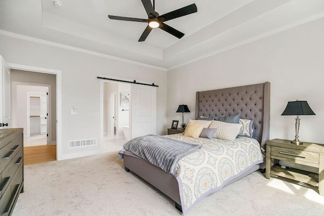 carpeted bedroom with ensuite bathroom, a raised ceiling, ceiling fan, and ornamental molding