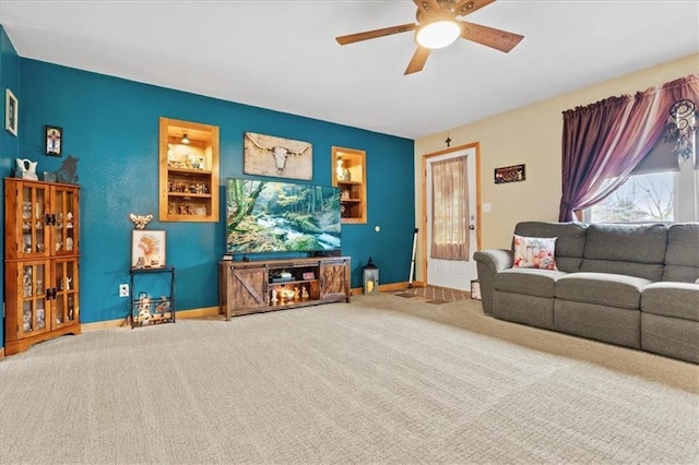 living room featuring ceiling fan, carpet, and built in features