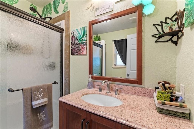 bathroom featuring vanity and an enclosed shower