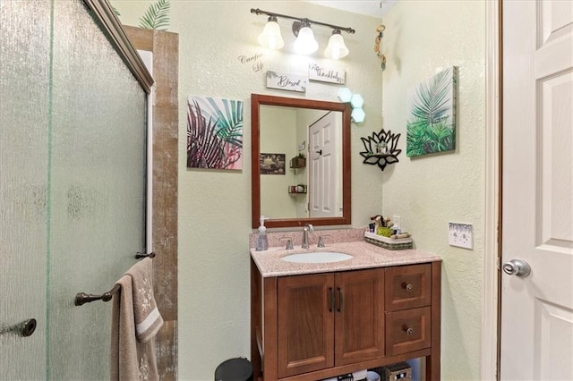 bathroom with a shower with door and vanity