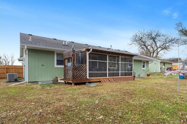 rear view of property with a yard, central AC, and a sunroom