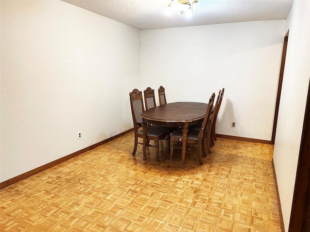 dining space with a textured ceiling and light parquet flooring