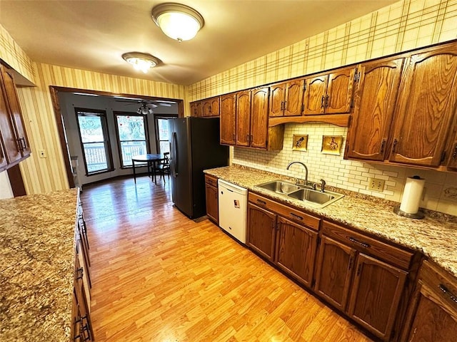 kitchen with ceiling fan, sink, tasteful backsplash, white dishwasher, and light hardwood / wood-style floors