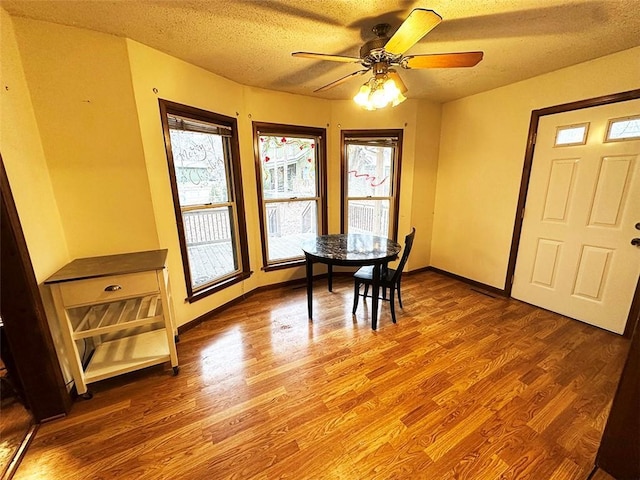 dining room with ceiling fan, hardwood / wood-style floors, and a textured ceiling