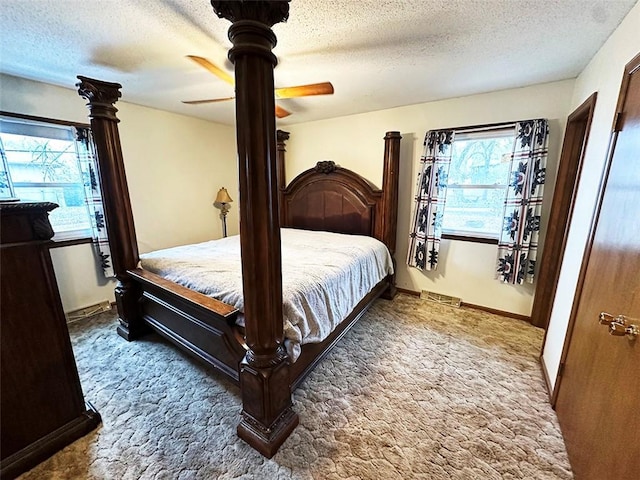 carpeted bedroom with a textured ceiling and ceiling fan