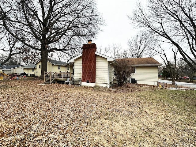 view of property exterior featuring central AC unit and a wooden deck