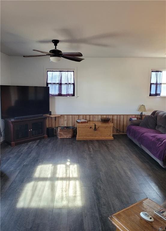 living room featuring ceiling fan and dark wood-type flooring