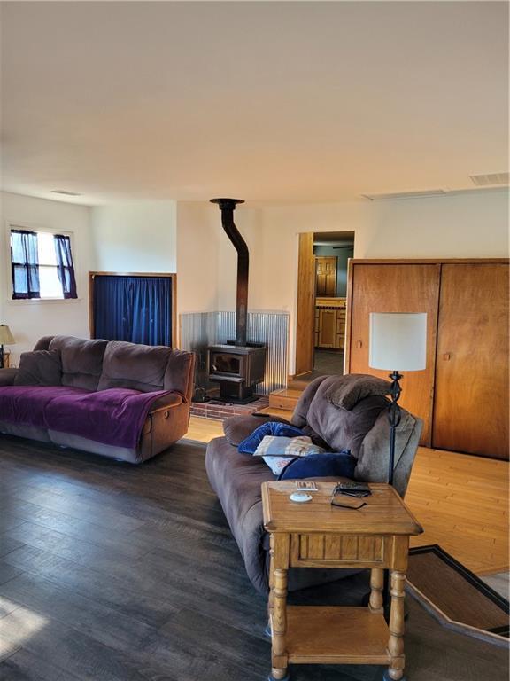 living room with wood-type flooring and a wood stove