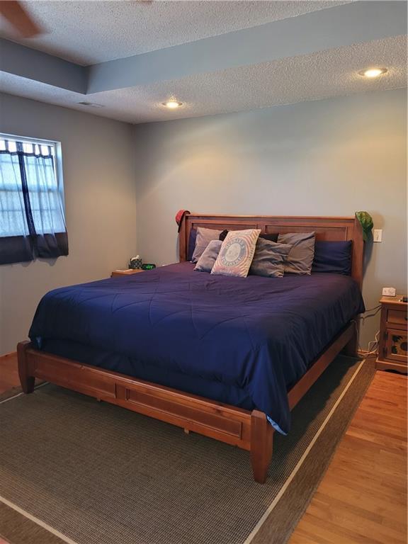 bedroom featuring hardwood / wood-style floors and a textured ceiling