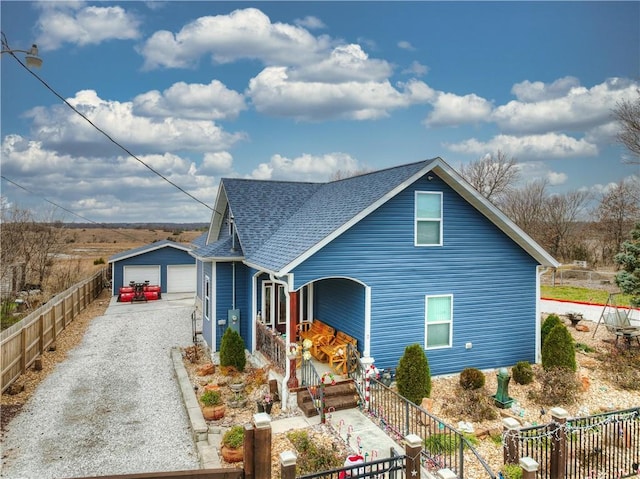 view of front of property featuring a garage, covered porch, and an outbuilding