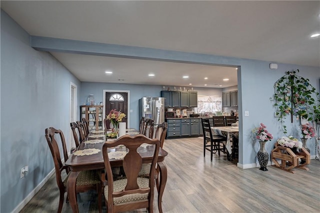 dining area featuring beamed ceiling and light hardwood / wood-style flooring