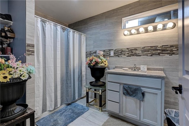 bathroom featuring tile patterned floors, curtained shower, vanity, and tile walls