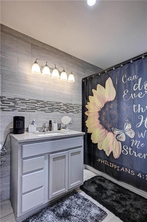 bathroom with vanity, tile walls, and walk in shower