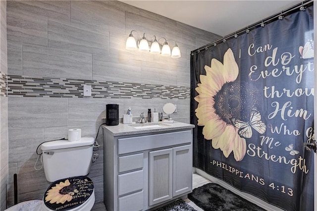 bathroom with curtained shower, vanity, tile walls, and toilet