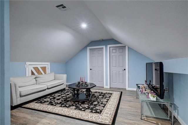 living room with hardwood / wood-style floors and vaulted ceiling