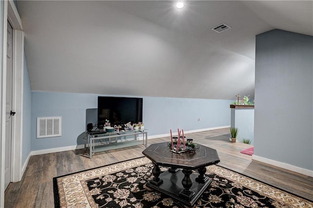 living room featuring hardwood / wood-style flooring and vaulted ceiling