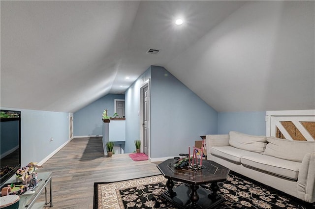 living room with vaulted ceiling and hardwood / wood-style flooring