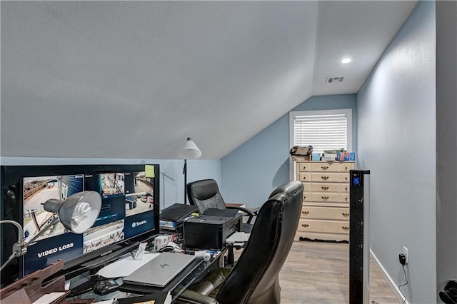 home office with light wood-type flooring and lofted ceiling