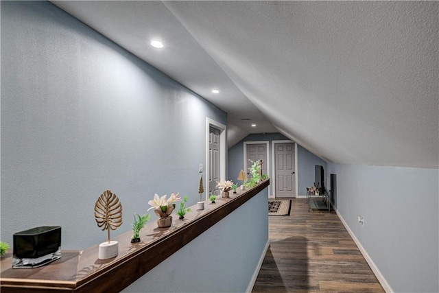 hallway with lofted ceiling and dark wood-type flooring