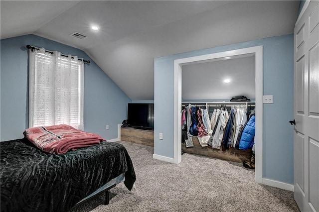 carpeted bedroom with vaulted ceiling and a closet