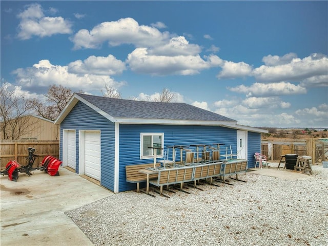 back of house featuring an outdoor structure and a garage