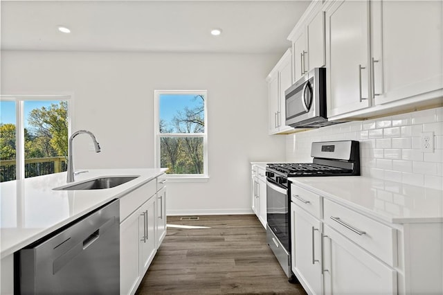 kitchen featuring white cabinetry, sink, stainless steel appliances, and plenty of natural light