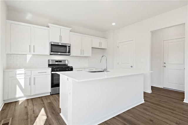 kitchen with sink, stainless steel appliances, white cabinetry, and an island with sink