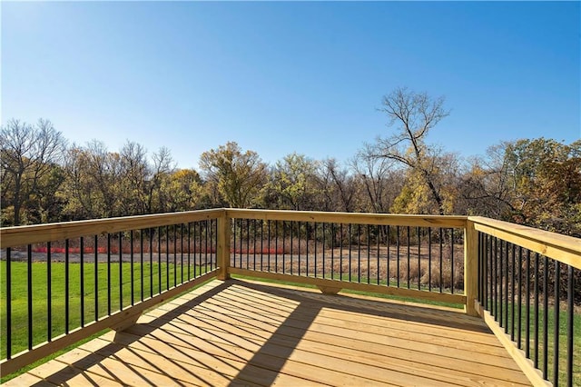 wooden deck featuring a lawn