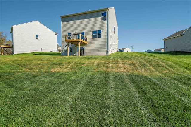 rear view of property with a yard and a deck